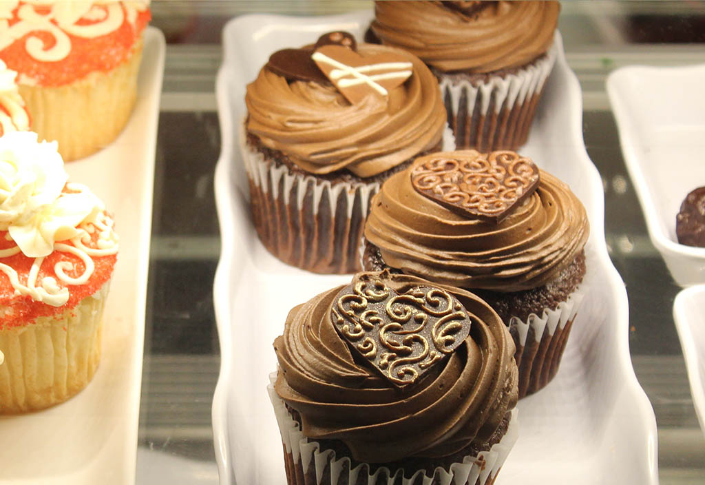 Chokladmuffins i en disk med chokladsmökräm och dekorerad med dekorativa chokladbitar.