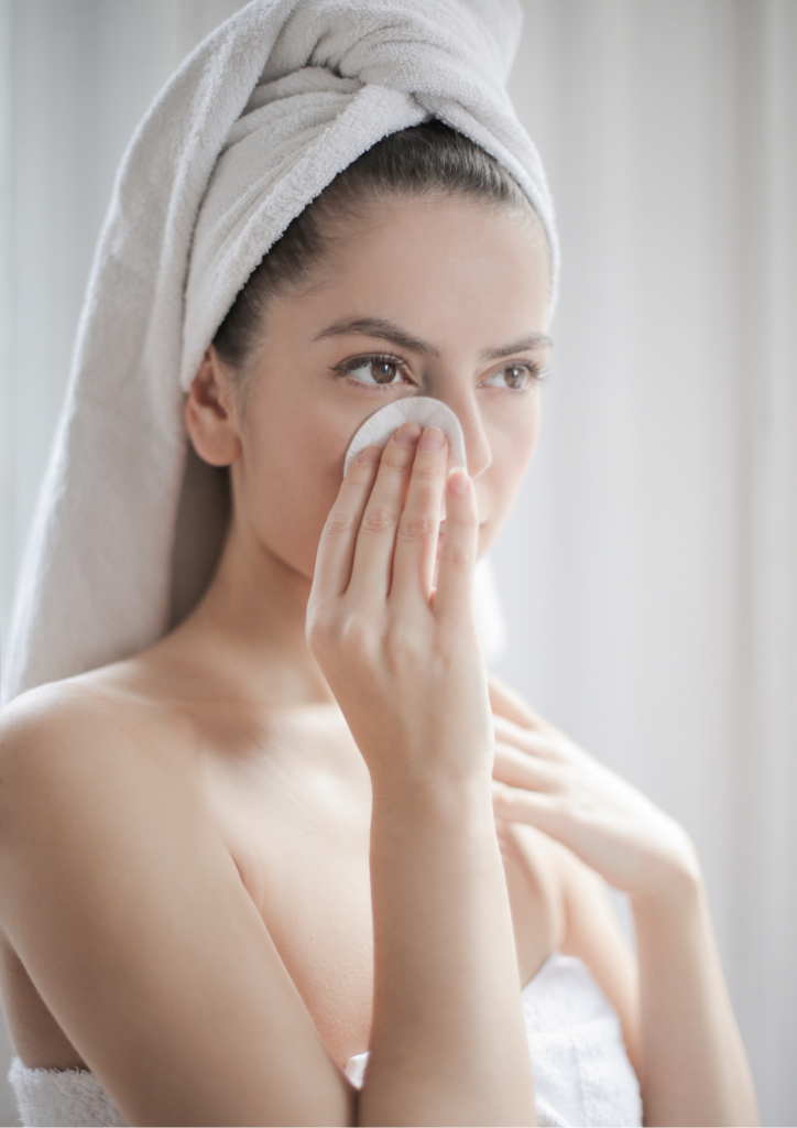 En kvinna som tvättar sig i ansiktet med pads.