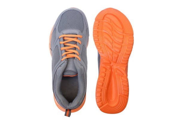 Ett par sko. En sko med orange sula upp.