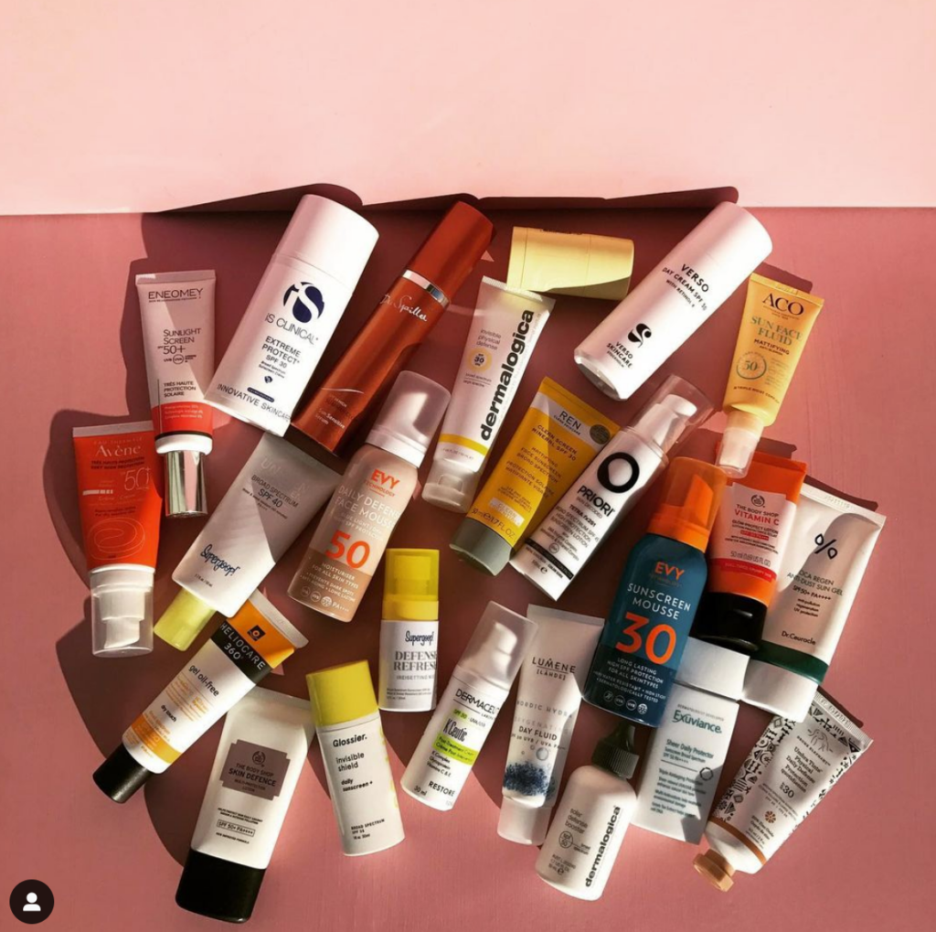 Bild på ett tretiotal hudvårdsprodukter från olika märken som ligger i solljus mot en skir bakgrund. 